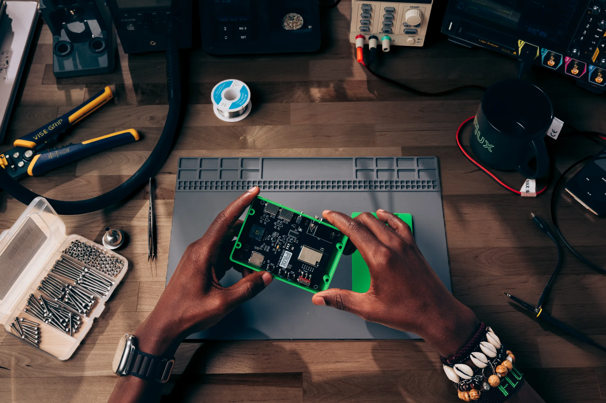 An engineer holds a board in a green enclosure