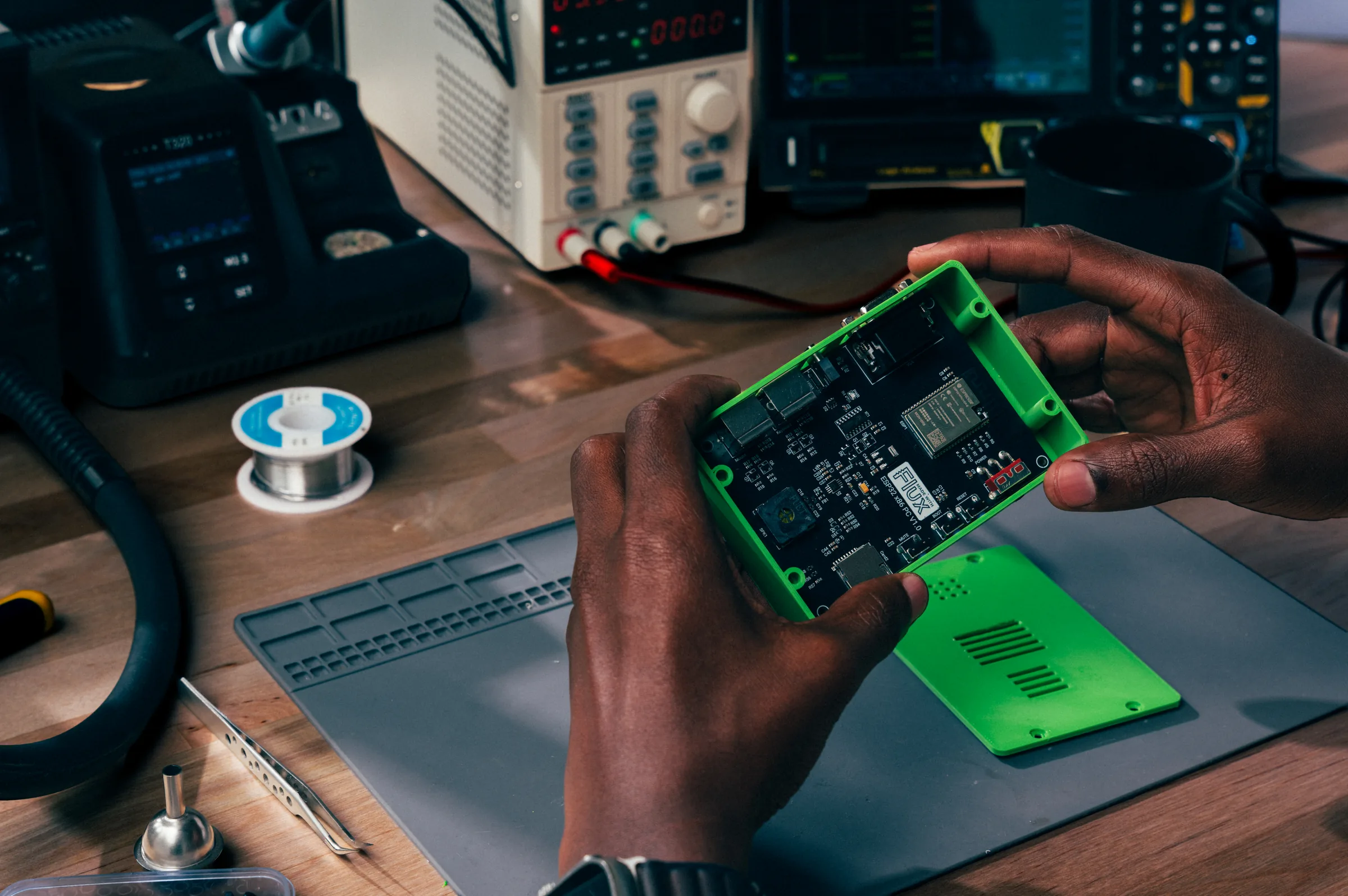 An engineer fits a board into a green 3D-printed enclosure