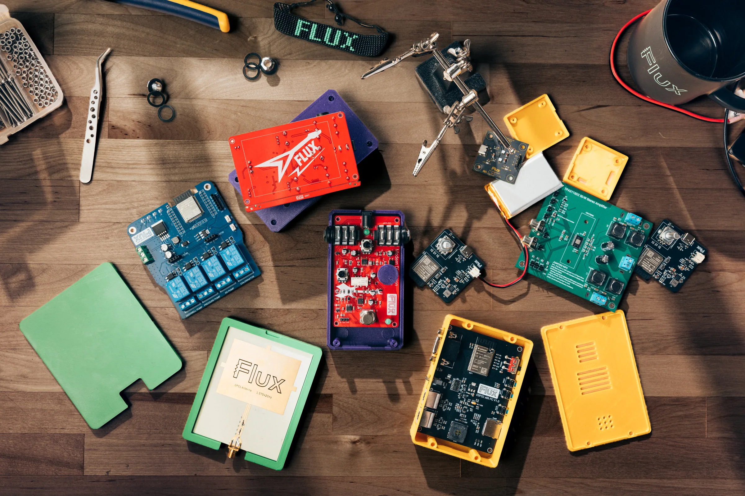 Boards and 3D-printed enclosures made with Flux on a workbench