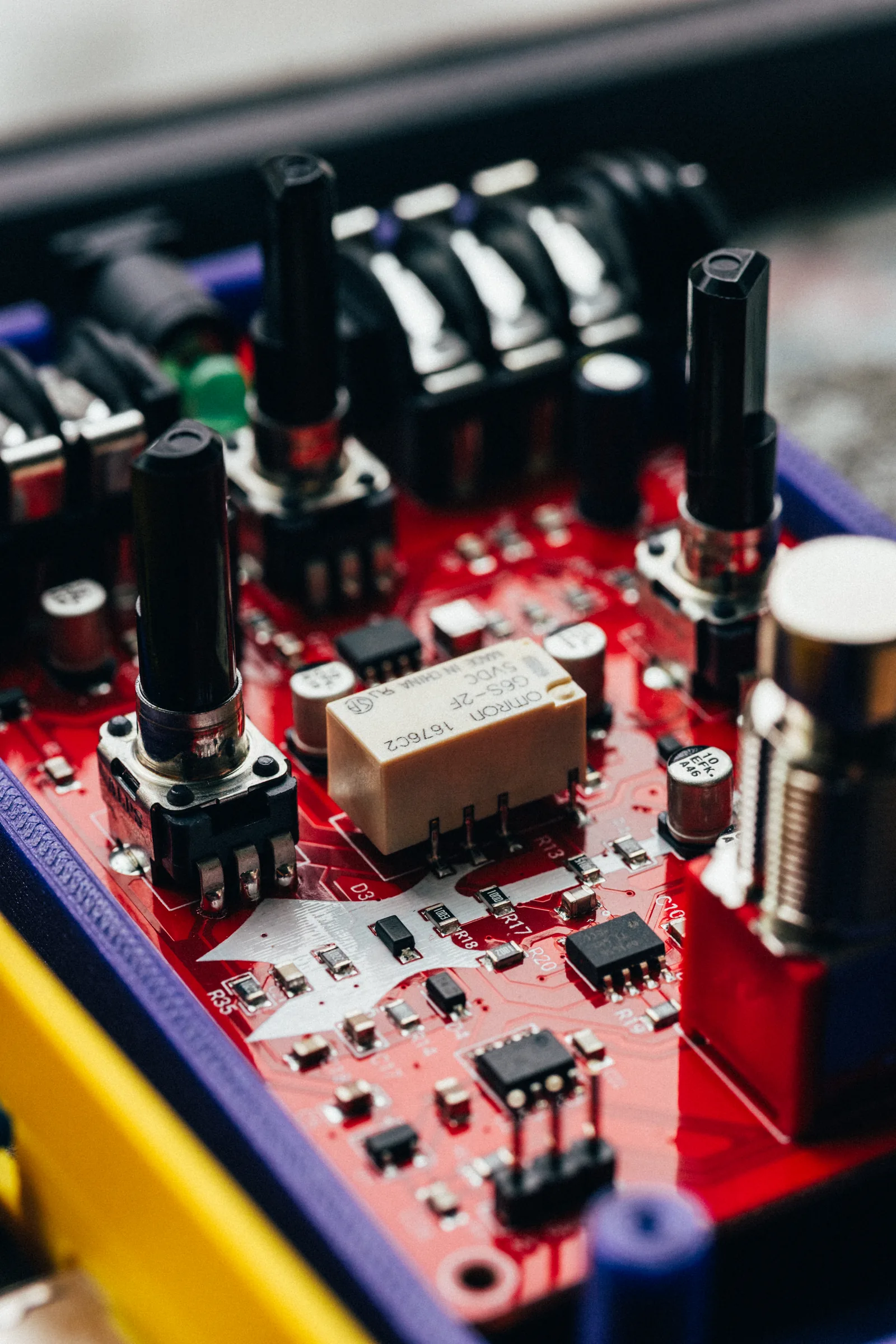 Close-up of a red guitar pedal board in its enclosure